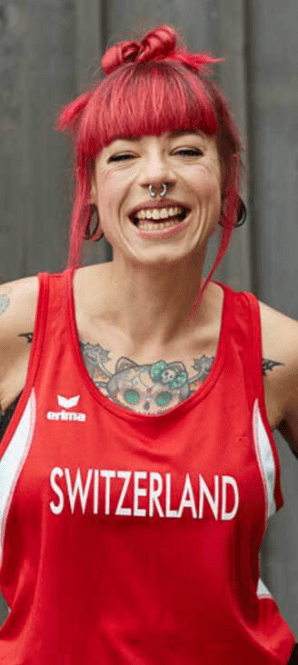 WW Mitglied Miranda lächelt in die Kamera und trägt ein Oberteil, auf dem "Switzerland" steht.
