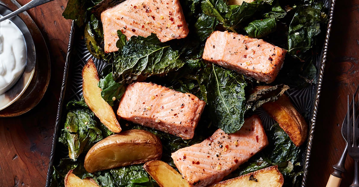roasted salmon in a sheet pan with crispy kale and golden potatoes