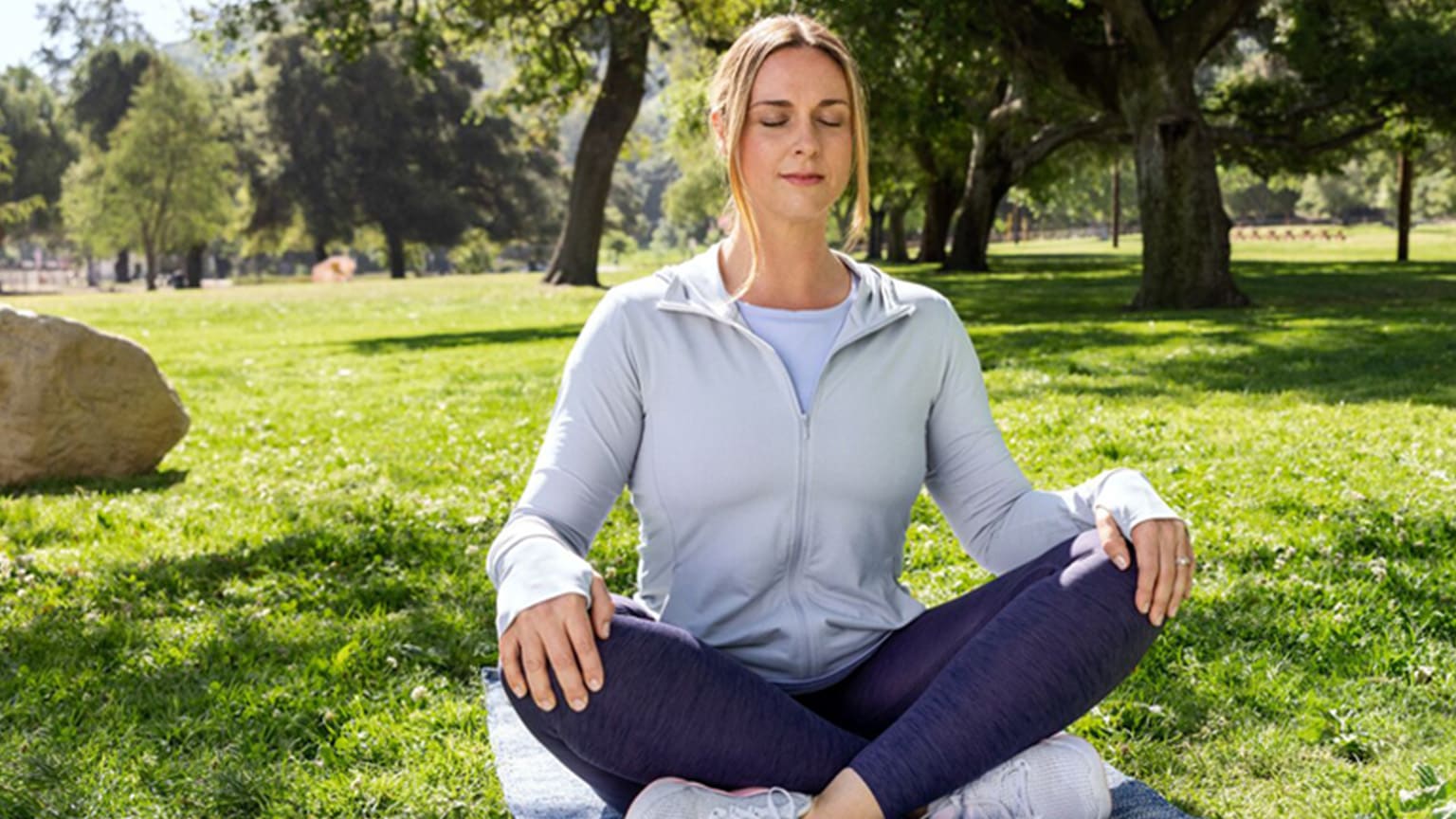 WW Mitglied Nicole meditiert im Park.