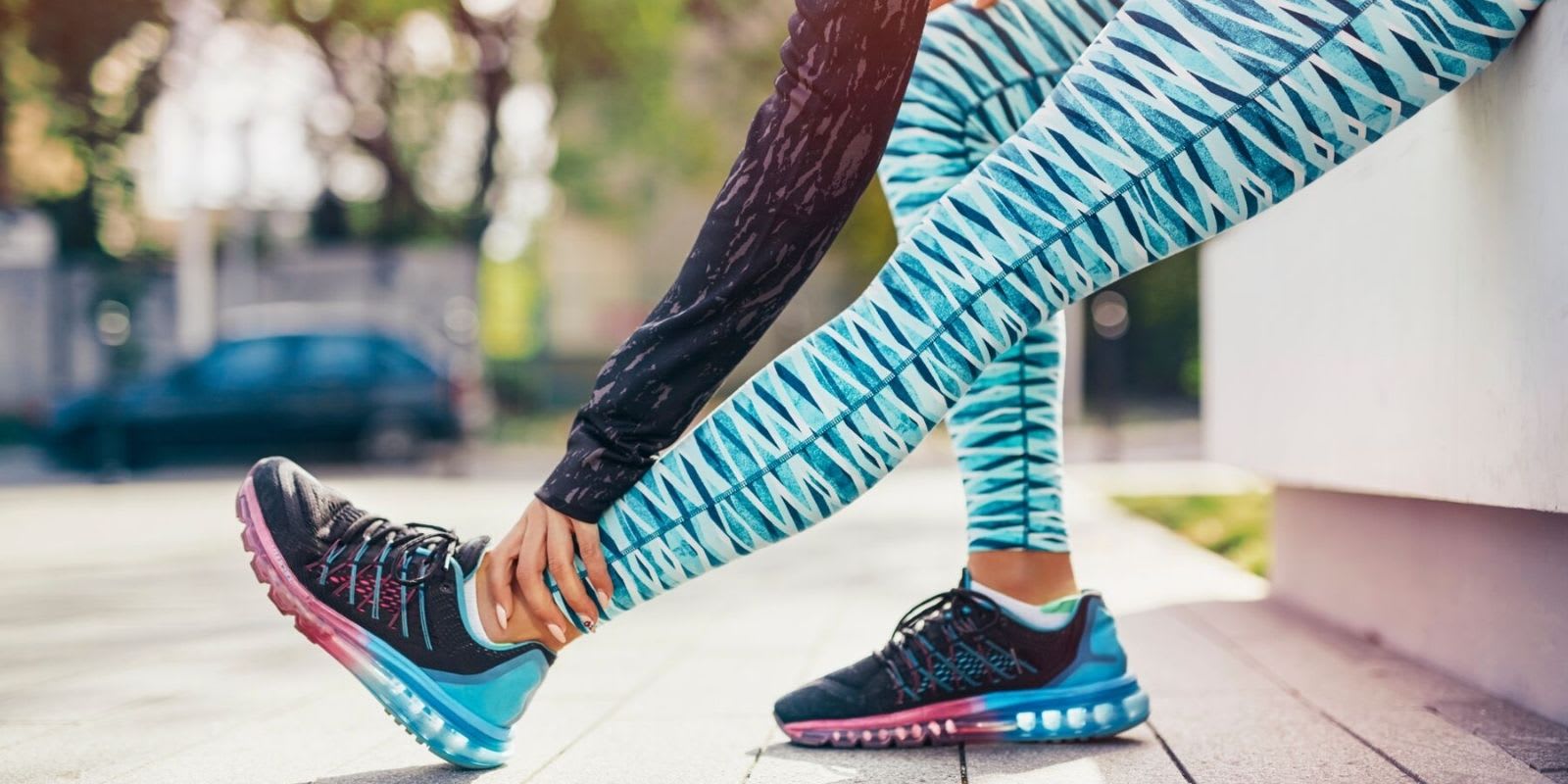Une femme en tenue de sport colorée étire ses jambes