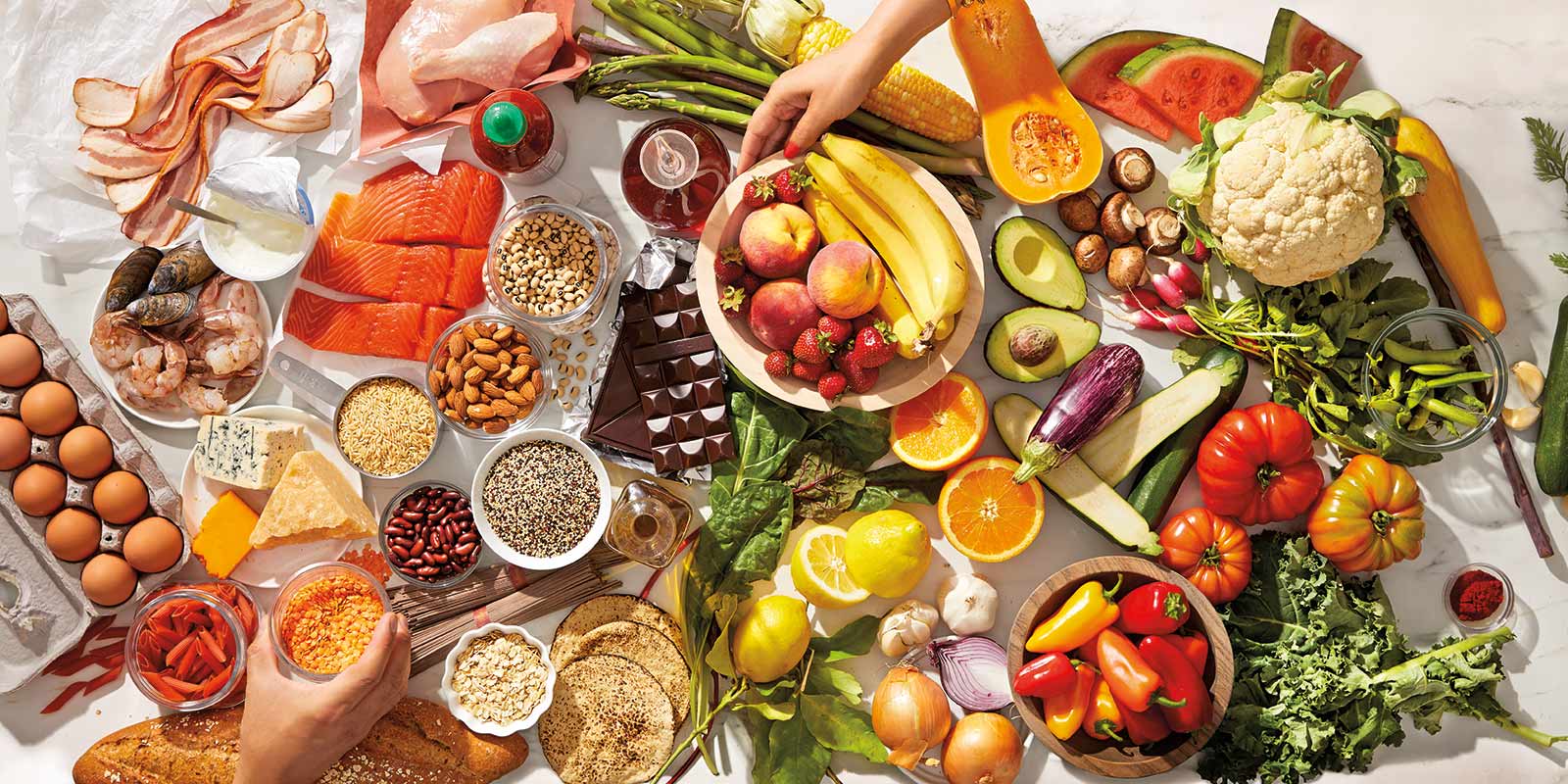 Ein Tisch ist gedeckt mit vielen ZeroPoint Lebensmitteln wie frischem Obst, Gemüse, Fisch, Eiern etc.