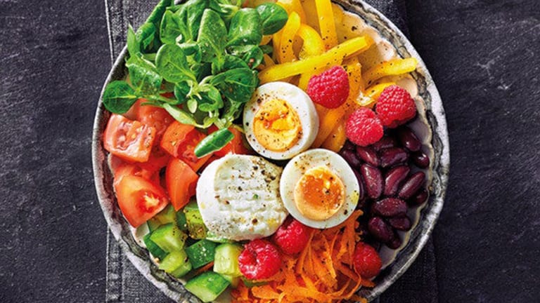 Eine Bowl mit frischem Gemüse, Huelsenfruechten, Käse und Ei