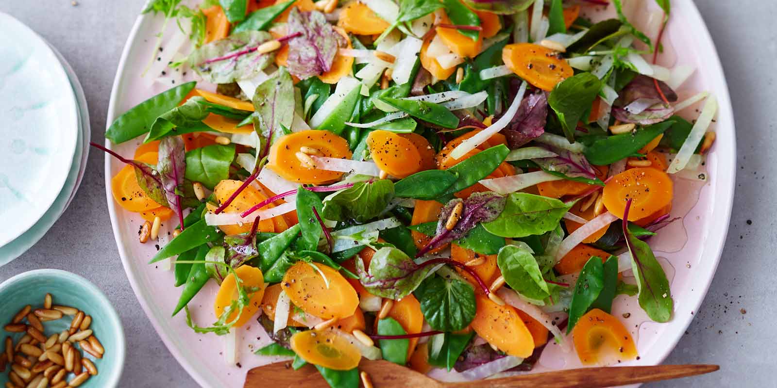 Ein Teller mit einem frischen Kohlrabi-Karotten-Salat mit Pinienkernen