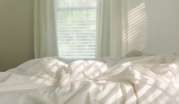 Image d'une chambre à coucher avec un lit avec des draps blancs