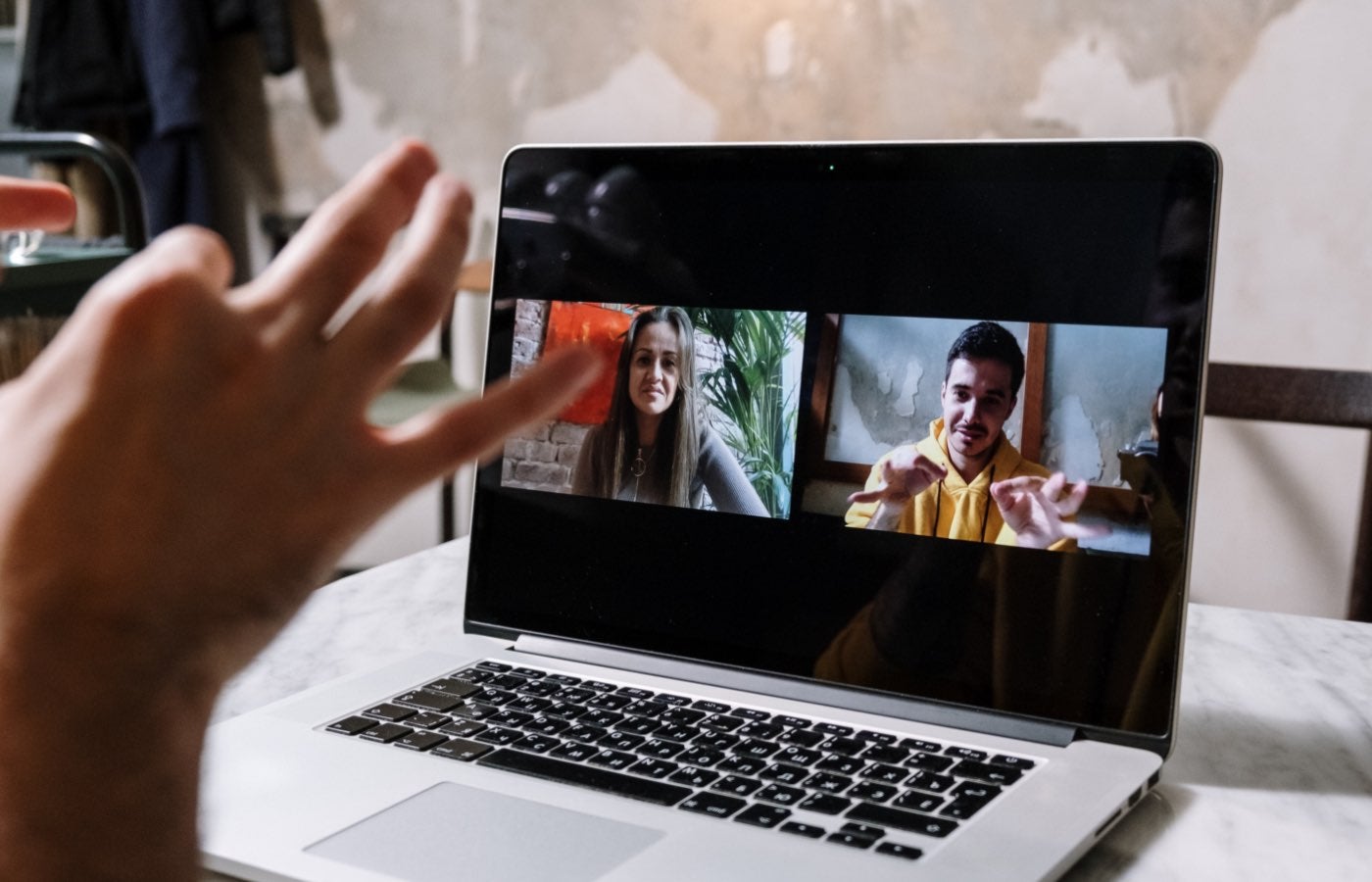 group of three people using sign language on a video call.