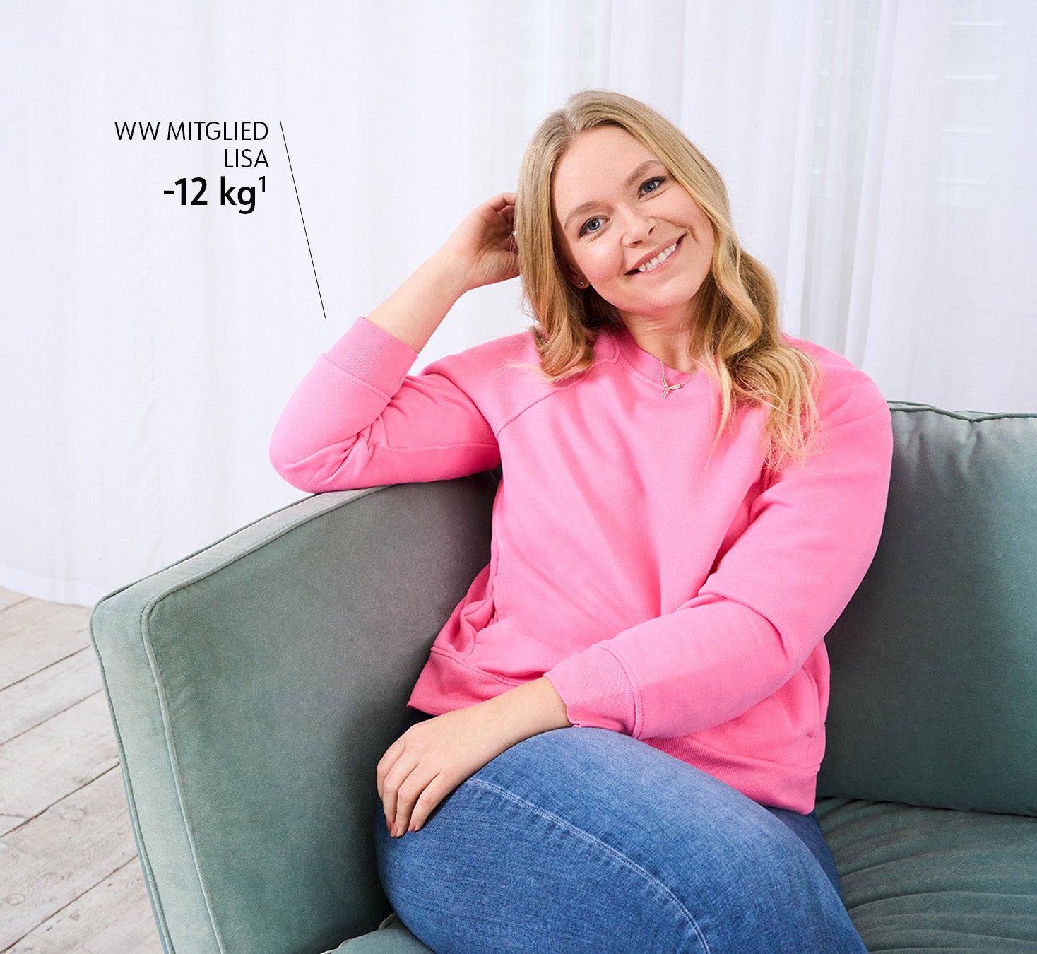WW Mitglied Lisa in rosa Pullover sitzt auf Sofa