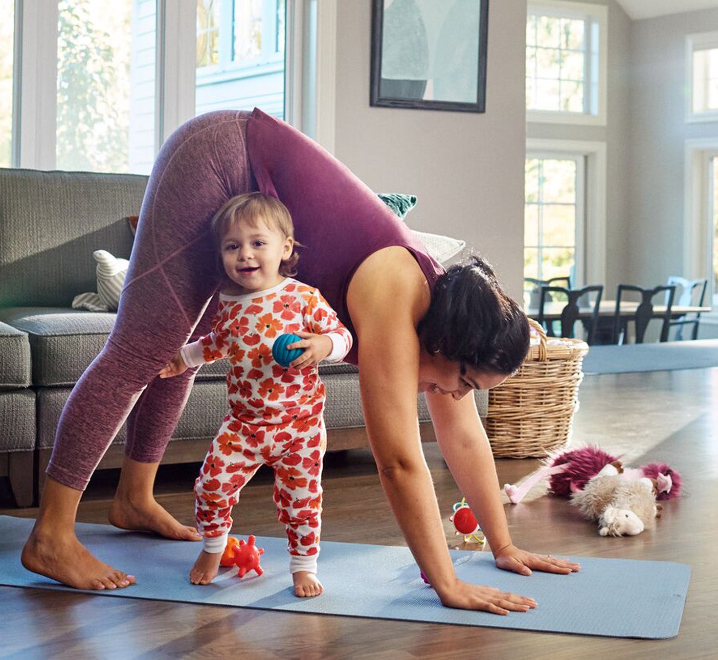 Une femme fait du yoga et un petit enfant joue à côté