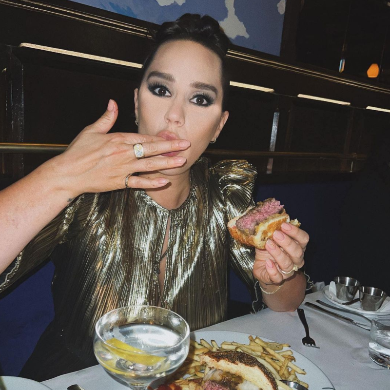 Pia out at a restaurant, enjoying a sandwich, fries, and a drink